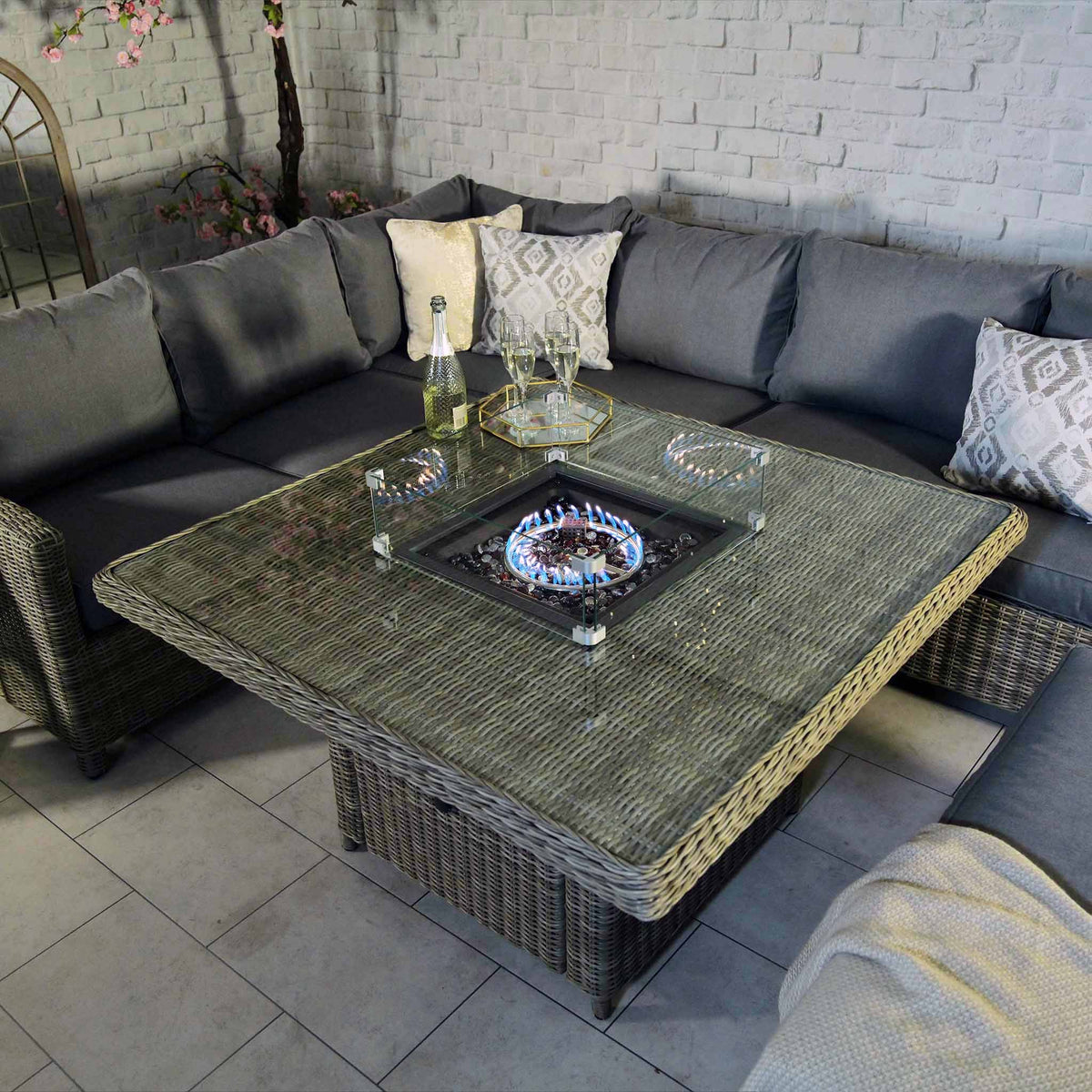 Wentworth Rattan 120cm Fire Pit Garden Dining Table & Lounge Set - close up of lit fire pit table